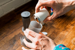 Ground coffee beans being poured into a AeroPress
