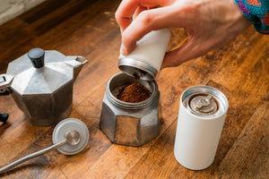 Close up image of freshly ground coffee beans being tipped into a Mokapot