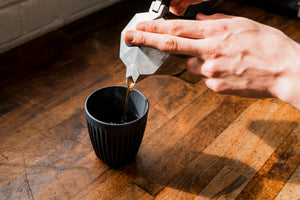 Small Batch Coffee Roastery Coffee being poured from a Mokapot into a black cup