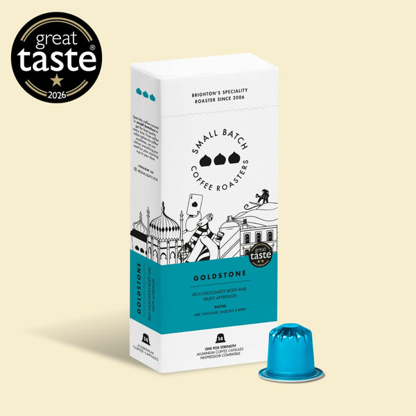 Goldstone Coffee Roasters Small Batch Roaster box in white and teal packaging, shown with a single blue coffee capsule on a light beige background. A black 'great taste 2026' award badge is displayed in the top-left corner.