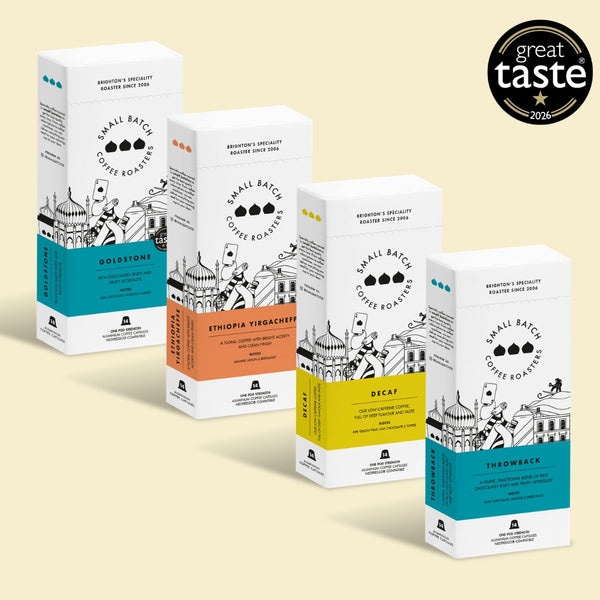 Four boxes of Small Batch Coffee Roasters in different flavors and roast levels, arranged diagonally on a light beige background with a 'great taste 2023' award badge in the top right corner.